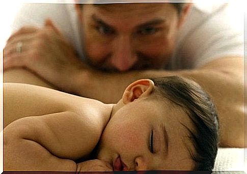 In dad's arms - dad watches over sleeping baby