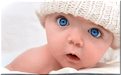 Blue-eyed baby looks at the camera.