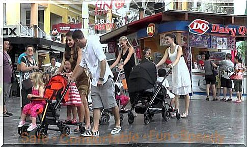 Parents push children in strollers.