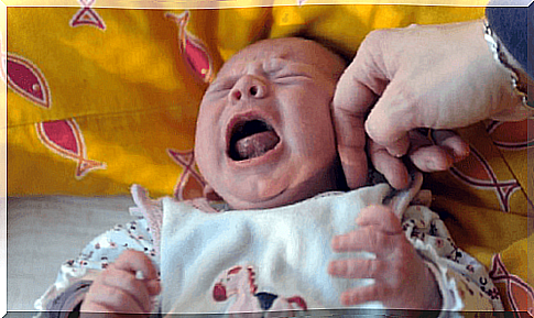 Crying baby with colic while breastfeeding