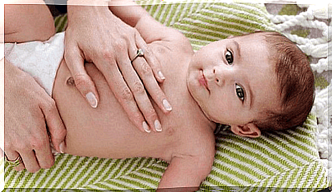 Baby is given colic massage while breastfeeding